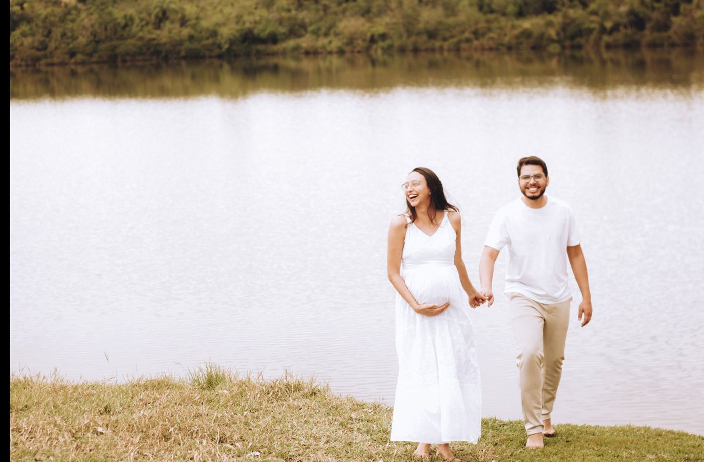 Isabel grávida de mãos dadas com o Igor à beira de um lago